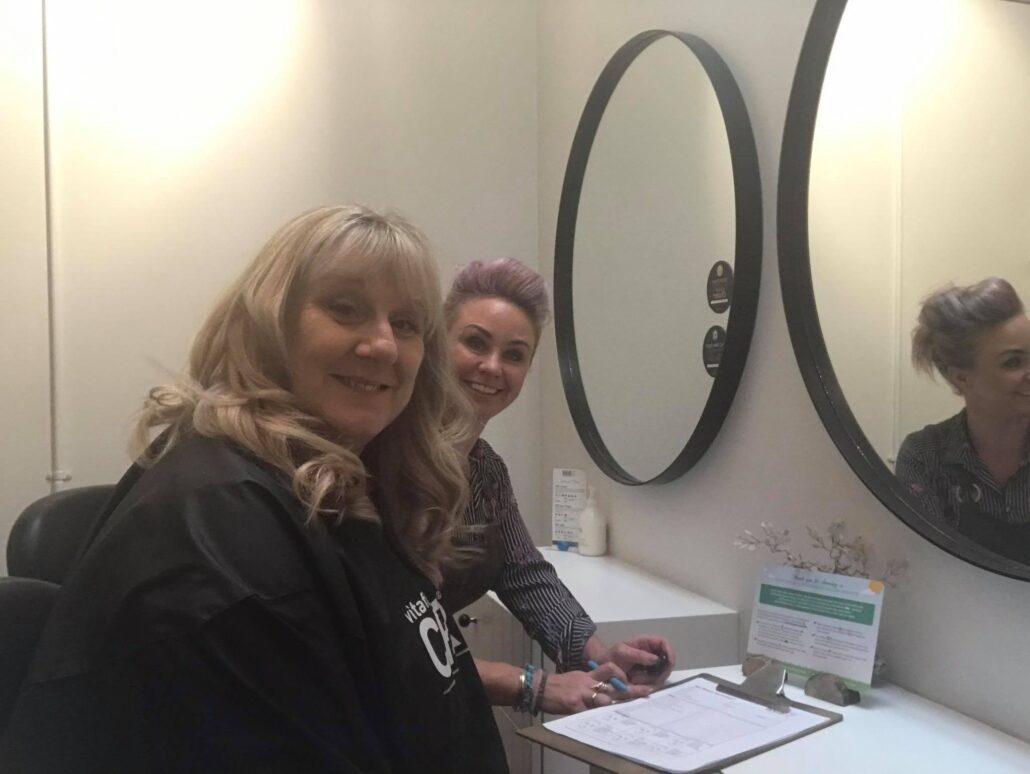 Kelly and client assessing hair